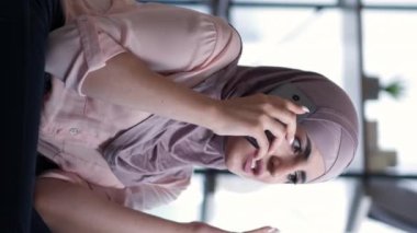 Dikey video. Sinir bozucu bir telefon. Telefon tartışması. Evdeki kötü haber servisinden rahatsız olup hücrede kavga eden sinirli bir kadın..