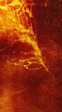 Dikey video. Işıltılı arka plan. Şenlik ateşi yanıyor. Turuncu parlayan sıcak bulanık alev soyut duman sıvısı boya akışı koyu yaratıcı sanatta altın parıltı ile.