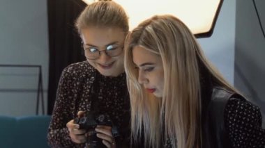 Sahne arkası fotoğraf çekimi. Profesyonel fotoğraf. Stüdyoda fotoğraf düzenlemeyi tartışan dizüstü bilgisayar ve kamera kullanan kızlar.