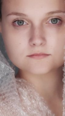 Dikey video. Plastik ambalaj. Atık yönetimi. Endişeli, düşünceli, gönüllü bir çevreci kadın biyolojik olarak çözülemeyen çöp poşeti geçmişi üzerine çalışıyor..