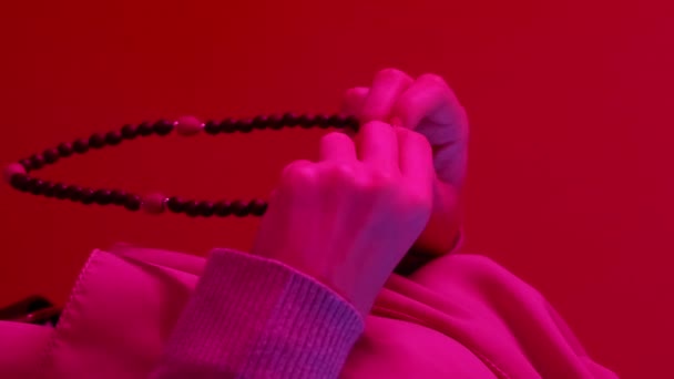 垂直录像 木制念珠 斋月祈祷 无法辨认的女人在红色复制空间背景的霓虹灯下手拿着山楂珠祈祷 — 图库视频影像