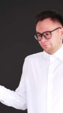 Dikey video. Belirsiz omuz silkme. Hiçbir fikrim yok. Cehaletten kuşkuluyum. Hiçbir şeyden haberi olmayan, dikkatsiz, zeki bir adam, siyah üzerine izole edilmiş omuzlarını kaldırıyor..