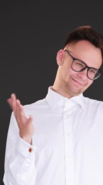 Dikey video. Şöyle böyle bir jest. Kesin bir cevap yok. Şüpheli bir ifade. Şüpheci, tatminsiz, bilgisiz, kararsız el işaretleri gösteren adam, siyah üzerine izole edilmiş..