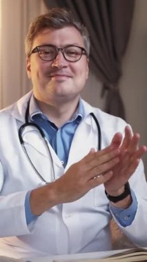 Dikey video. Destekleyici doktor. Tedavi başarılı oldu. Sağlık sigortası kutlaması. Mutlu adam pratisyen hekimler el çırpıyor..