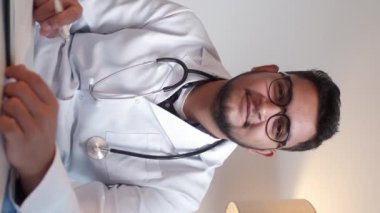 Dikey video. Sağlık uzmanıyım. Pratisyen hekim. Teletıp konferansı. Dost canlısı doktor doktor doktor klinikteki randevusunda..