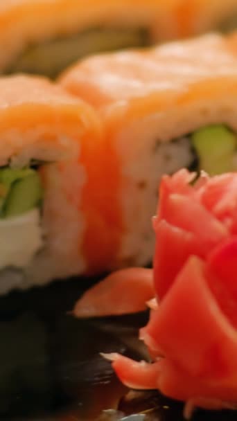 垂直录像 寿司味道鲜美日本卷 人的手拿起一块用筷子做的亚洲菜东方菜馆 — 图库视频影像