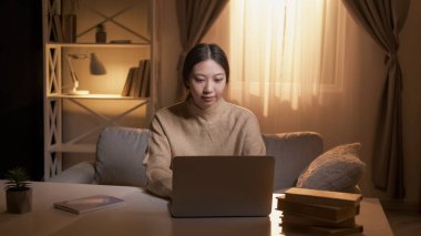 Çevrimiçi test. - Kız öğrenci. Ağ bağlantısı. Dizüstü bilgisayarda çalışan konsantre bir kadın iç odada oturuyor..