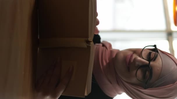 Vídeo Vertical Livro Café Ler Lazer Mulher Concentrada Hijab Óculos — Vídeo de Stock