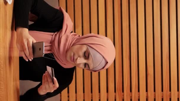 バーティカルビデオ オンライン決済 モバイルウォレット カフェで注文するインターネットストアでクレジットカードで購入するヒジャブの美しい女性 — ストック動画