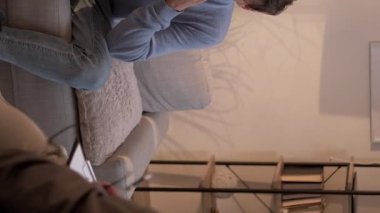 Dikey video. Danışmanlık terapisi. Psikoloji tedavisi. Sağlık hizmetleri danışmanlığı. Psikolog, stres altındaki çivi yiyen adamın ruh sağlığını tartışıyor..