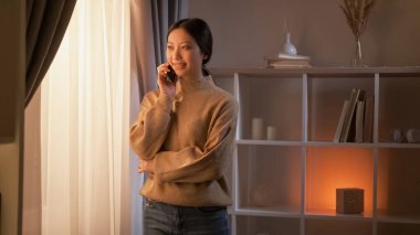 Mobil iletişim. Mutlu kadın. Hoş sohbetti. Neşeli ev hanımı pencerenin iç tarafında konuşmaktan zevk alıyor..