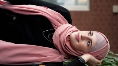 Dikey video. Kahve dükkânı eğlencesi. Kafe istirahatı. Kafiyeli rüya gibi bir kadın rahat şehir kahvesinde boş vakit geçirir..