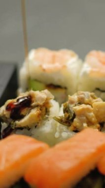 Dikey video. Suşi servisi. Yuvarlanma ayarlandı. Geleneksel Asya yemeği baharatlı soya sosu nefis Japon restoranında leziz yemek lezzeti döküyor..
