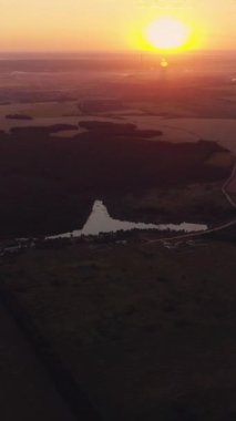 Dikey video. Hava kırsal manzarası. Gün doğumu manzarası. Yeşil alan sisli güneş ışığı drone üstgeçişi doğa manzarası ufuk çizgisi arka plan.
