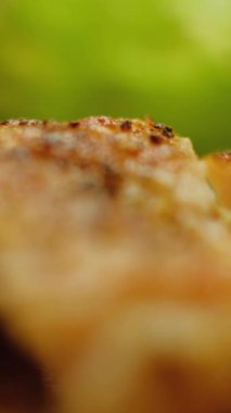 Dikey video. Tavuk eti. Kızarmış yemek. İnsan eli çatallı, sağlıklı, sulu, lezzetli, restoranda sağlıklı yemek yiyen bir parça alır..