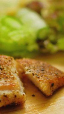 Dikey video. Tavuk göğsü. Sağlıklı beslenme. İnsan eli, lezzetli yemekler yiyen çatallı organik et parçalarını topluyor..