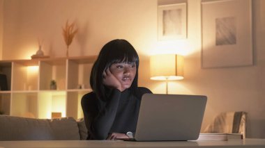 Gece çalışması. Çevrimiçi öğrenme. Öğrenci uykusuzluğu. Ev içi iş yerinde dizüstü bilgisayarda video izleyen yorgun bir kadın..