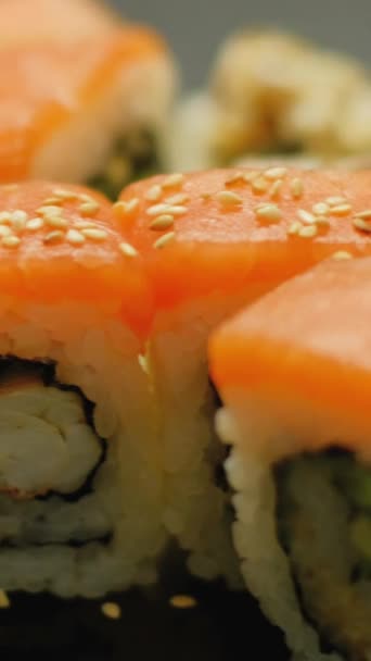 バーティカルビデオ サーモン寿司について 日本料理 レストランでゴマで飾られたおいしいロールのクローズアップ アジアの伝統的な食事 — ストック動画