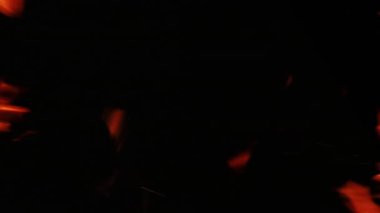 Dikey video. Yangın çerçevesi. Alev kıvılcımları. Yanan kaplama. Fotokopi uzayı ile siyah karanlık gece arkaplanı üzerinde turuncu kırmızı ışık sıcak alev parçacıkları.