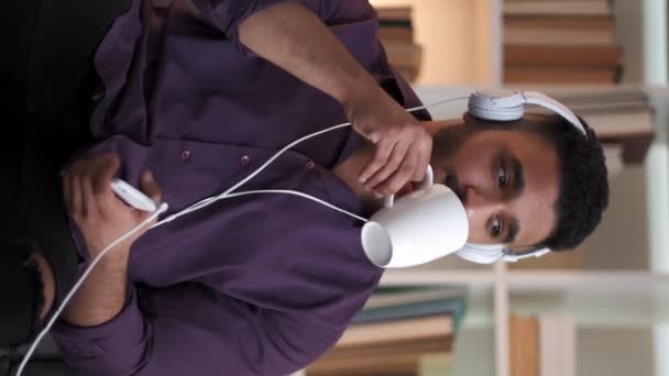 비디오 집에서 커피를 마시는 헤드폰에 오디오를 즐기는 편안한 펜시브 — 비디오