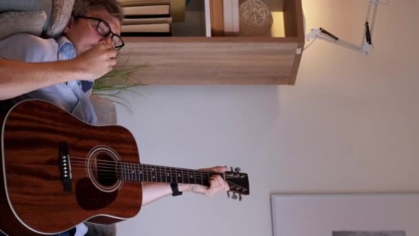垂直录像 天才音乐家 吉他的歌 在家里客厅里 躺在沙发上弹奏着乐器 唱着曲子的人受到了启发 — 图库视频影像
