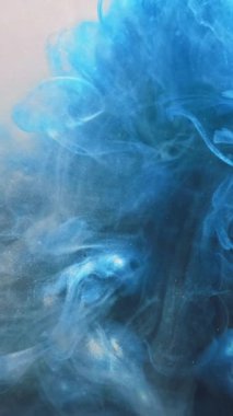 Dikey video. Suyu boya. Mürekkep sıçraması. Duman bulutu dokusu. Mavi renkli simli parçacıklar, yüzen hareket soyut sanat arkaplanı.