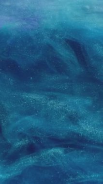 Dikey video. Pırıltılı sis. Renk dumanı. Fantezi bulutu. Mavi ışıldayan parçacıklar desen mürekkep akışı hareket soyut sanat arka planı.