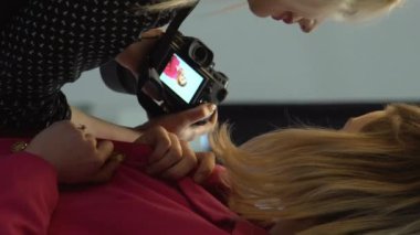 Dikey video. Sahne arkası kaydı. Fotoşop işlemi. Moda fotoğrafçısı ve model iletişimi stüdyoda yeni kıyafet koleksiyonu çekiyorlar..