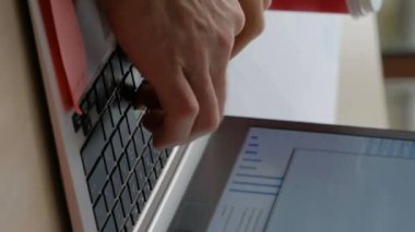 Dikey video. Laptop işi. İnternet işi. Dijital pazarlama. Ofisteki adam modern bilgisayar klavyesinde yazarken işyerindeki şirket sohbetleri için interneti kullanıyor..