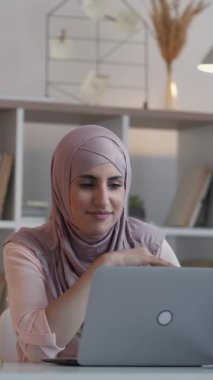 Dikey video. İnternet konferansı. Sanal koç. Çevrimiçi iletişim. Evde çalışan mutlu kadın bilgisayarlı uzaktan kumandalı ofis masasında toplantı çağrısı yapıyor..