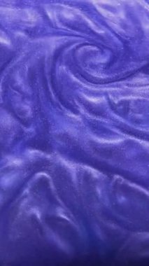 Dikey video. Parlak mürekkep girdabı. Suyu boya. Mor mavi renk ışıl ışıl sıvı dokusu fırıl fırıl fırıl dönerek yaratıcı sanat arkaplanı.