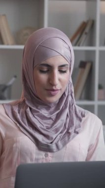 Dikey video. Laptop çağrısı. İnternet iletişimi. Çevrimiçi sohbet. Oturma odasındaki kanepede uzaktan internet konferansında gülümseyen kadın..