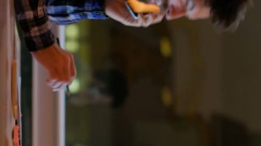 Dikey video. İş anlaşması. Satış başarısı. Gülümseyen adam ofisi uzmanı iş arkadaşı kadınla telefonda konuşuyor. Akşamları modern iş yerinde bilgisayarlı bir beşlik çakıyor..