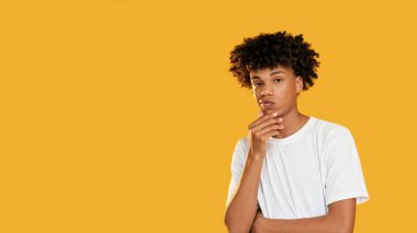 Dalgın bir yüz. Sorun tefekkür. Kafası karışmış meraklı adam sarı boş alan arka planında izole olduğunu düşünüyor..