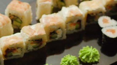 Suşi seti. Yuvarlanıp yiyor. İnsan eli Asya yemeği topluyor Japon mutfağı lezzetli lezzetli yemekler restoranda.