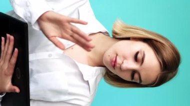 Dikey video. Dijital proje. İşletme. Görevi tamamla. Verimli bir iş. Mutlu ofis kadını gülüşü mavi tablette yalnız başına yazarken..