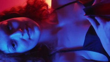 Dikey video. Sevgililer günü hediyesi. Doğum günü hediyesi. Şaşırmış neşeli sevgili kadın mücevher çantasını aç mutlu iç çekiş akşam elbisesi kırmızı mavi ışık.