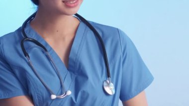 Tıbbi asistanım. Kadın doktor. Neşeli sakin terapist yan gülümseme dikkat et açık el, üniforma hizmeti mavi arka plan.