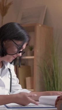 Dikey video. Hasta danışmanlığı. Destekleyici doktor. Profesyonel sağlık hizmeti. Dost canlısı kadın pratisyen hekime hastanede kadın teşhisi konuldu diyor..