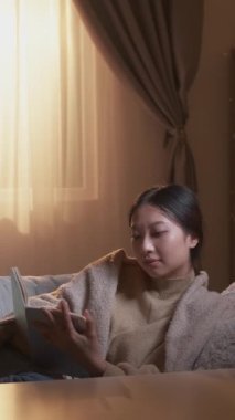 Dikey video. Hobi yazıyorum. Hafta sonu tatili. Olumlu anılar. Rahat, ilham verici bir kadın günlüğe not alıyor. Oda içindeki rahat koltukta..