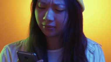 Çığlık atan telefon. Bağlantı kötü. Kızgın öfkeli milenyum kadını bağrışma cihazını tartışıyor hoşnutsuz konuşma sarı açık turuncu gradyanı.