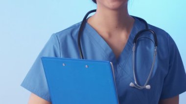 Hemşire kadın. Tıbbi pratisyen. Neşeli dost canlısı hastane personeli profesyonel doktor steteskop mavi üniforma dosya geçmişi.