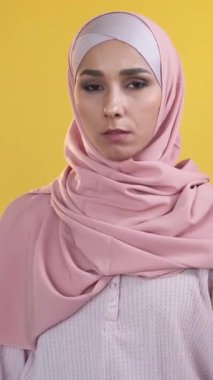 Dikey video. Bu kadar hareket. Reddetmek yok. Kadın protestosu. Kaçık, tesettürlü, çapraz el hareketi yapan, turuncu üzerine izole edilmiş, dur işareti veren kadın..