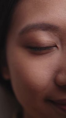 Dikey video. Yarı yüz güzellik. Doğal cilt bakımı. Sağlık kozmetolojisi. Çıplak makyajlı, kendinden emin, mutlu kadın..