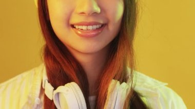 Neşeli bir genç. Müzik yaşam tarzı. Neşeli gülümseyen kuşak z kız arkadaş canlısı stil kulaklık takan sıcak sarı neon ışıklı fotokopi alanı.