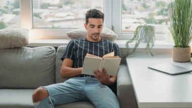 Okumaktan zevk alıyorum. Hafta sonu tatili. Rahatlatıcı hobi. Huzurlu bir adam rahat bir koltukta oturuyor ve evinde, gün ışığında en çok satanlar kitabıyla oturuyor..