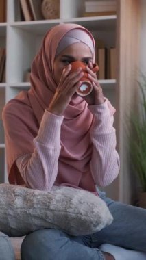 Dikey video. Kahve gevşedi. Ev tefekkür. Hafta sonu sabahı. Sıcak içkinin tadını çıkaran mutlu, düşünceli bir kadın..