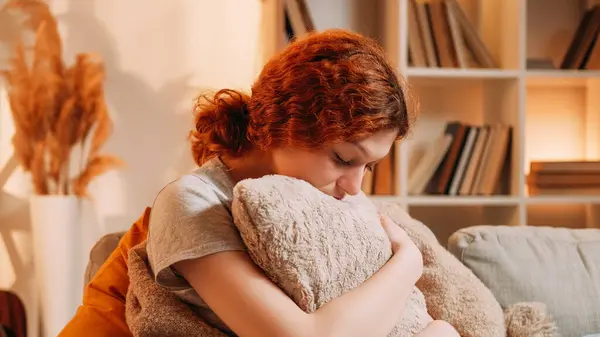 stock image Lonely woman. Depression anxiety. Sad unhappy millennial female hugging fluffy pillow melancholy bad thought feel solitude alone hopeless on cozy sofa at home.