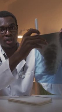 Dikey video. Sanal doktor. Akciğer taraması. Radyoloji kontrolü. Coronavirus pulmoner enfeksiyonu. Erkek doktor konsültasyonu göğüs röntgeni çekiliyor..