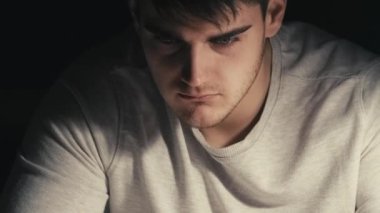 Gece yorgunluğu. Konsantrasyon aranıyor. Çevrimiçi kariyer. Gece vakti karanlık odada dizüstü bilgisayarda yazı yazan kararlı erkek serbest yazar..